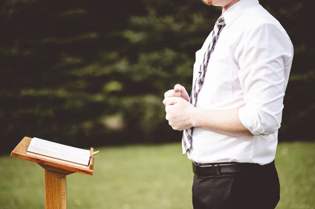 selective focus shot young male standing front wooden church stand